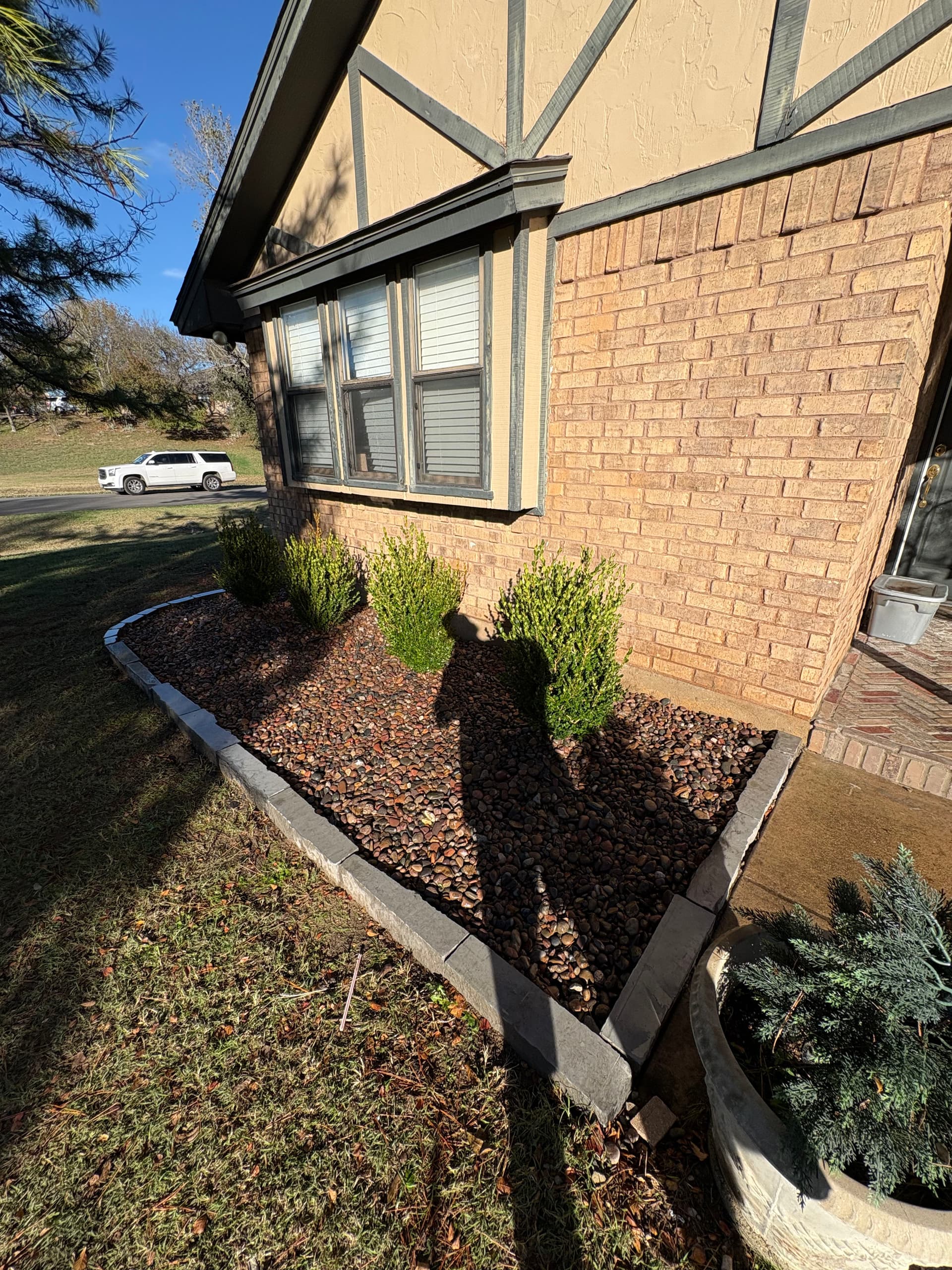 Elegant Landscaping with Herringbone Porch and Rock Beds